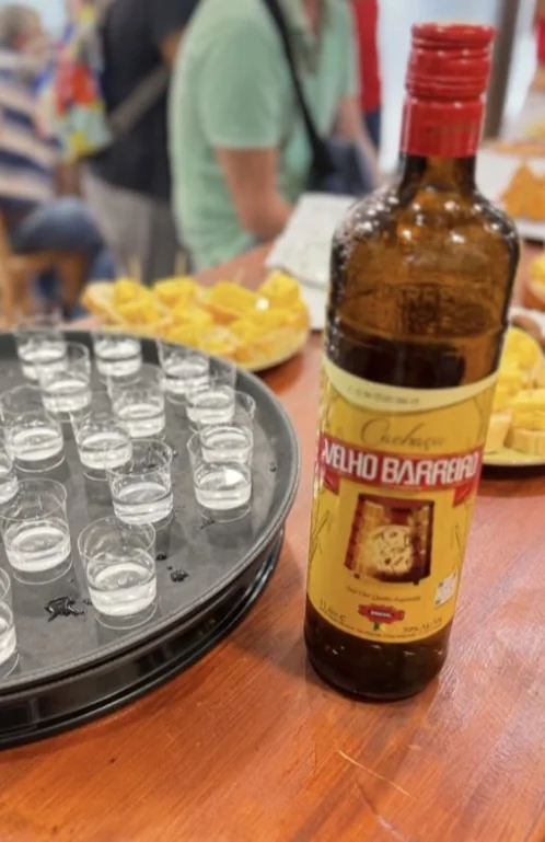 Botella de cachaça Velho Barreiro junto a chupitos y pinchos